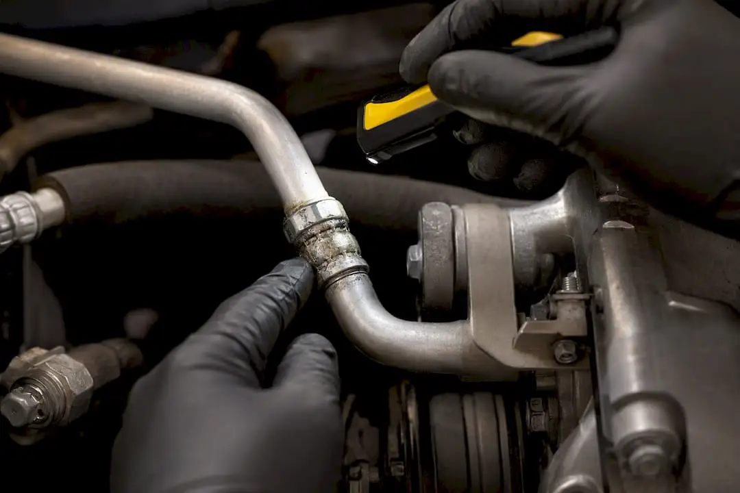 Technician inspecting oily AC line residue